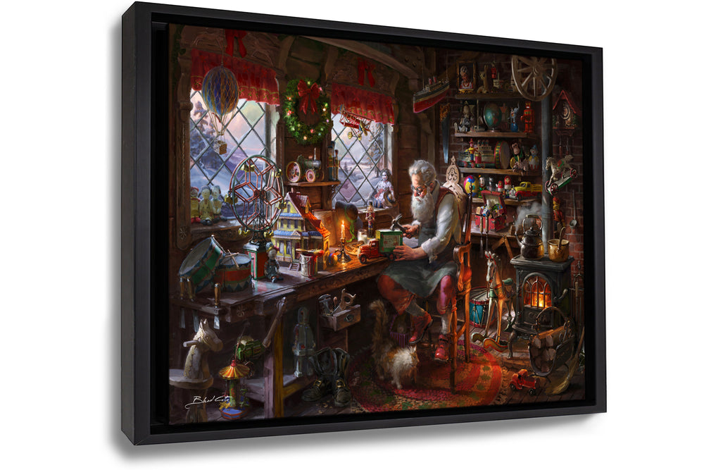 A framed art print on canvas of the painting of Santa claus making toys in his workshop  during christmas with a cat by his boots and wood burning stove amongst the many children's toys.
