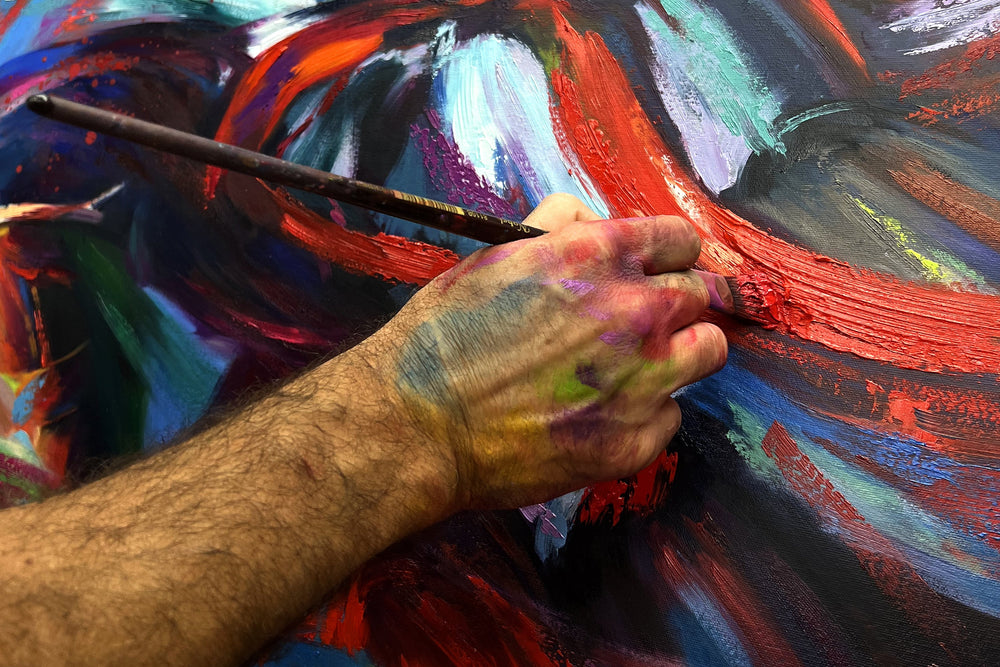 Detailed view of artist hand embellishing limited edition painting.